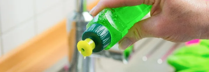 Hand hält Spülmittelflasche